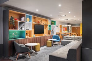 Relax in the lounge area with a sectional sofa, armchairs, and a flat-screen TV.