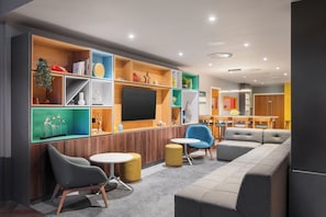 Relax in the lounge area with a sectional sofa, armchairs, and a flat-screen TV.