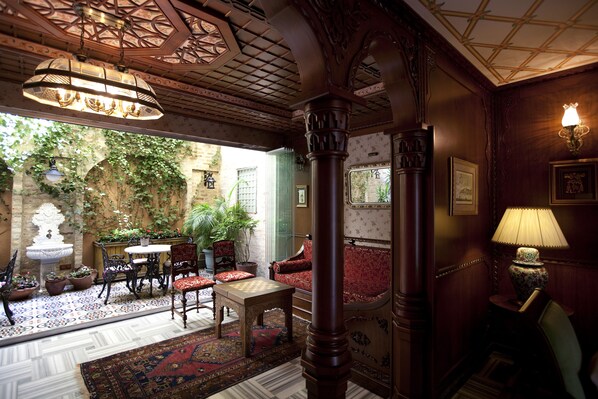 A traditional room with a patterned floor, a wooden table, chairs, a sofa, and a decorative lamp. - Niles Hotel Istanbul - Special Class (Istanbul)