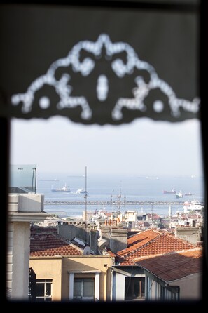 A coastal cityscape with visible rooftops and a distant view of the sea. - Niles Hotel Istanbul - Special Class (Istanbul)