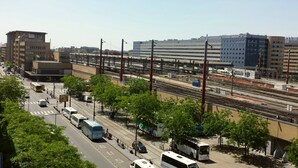 Une gare ferroviaire avec de nombreuses voies, une gare routière et les bâtiments environnants.