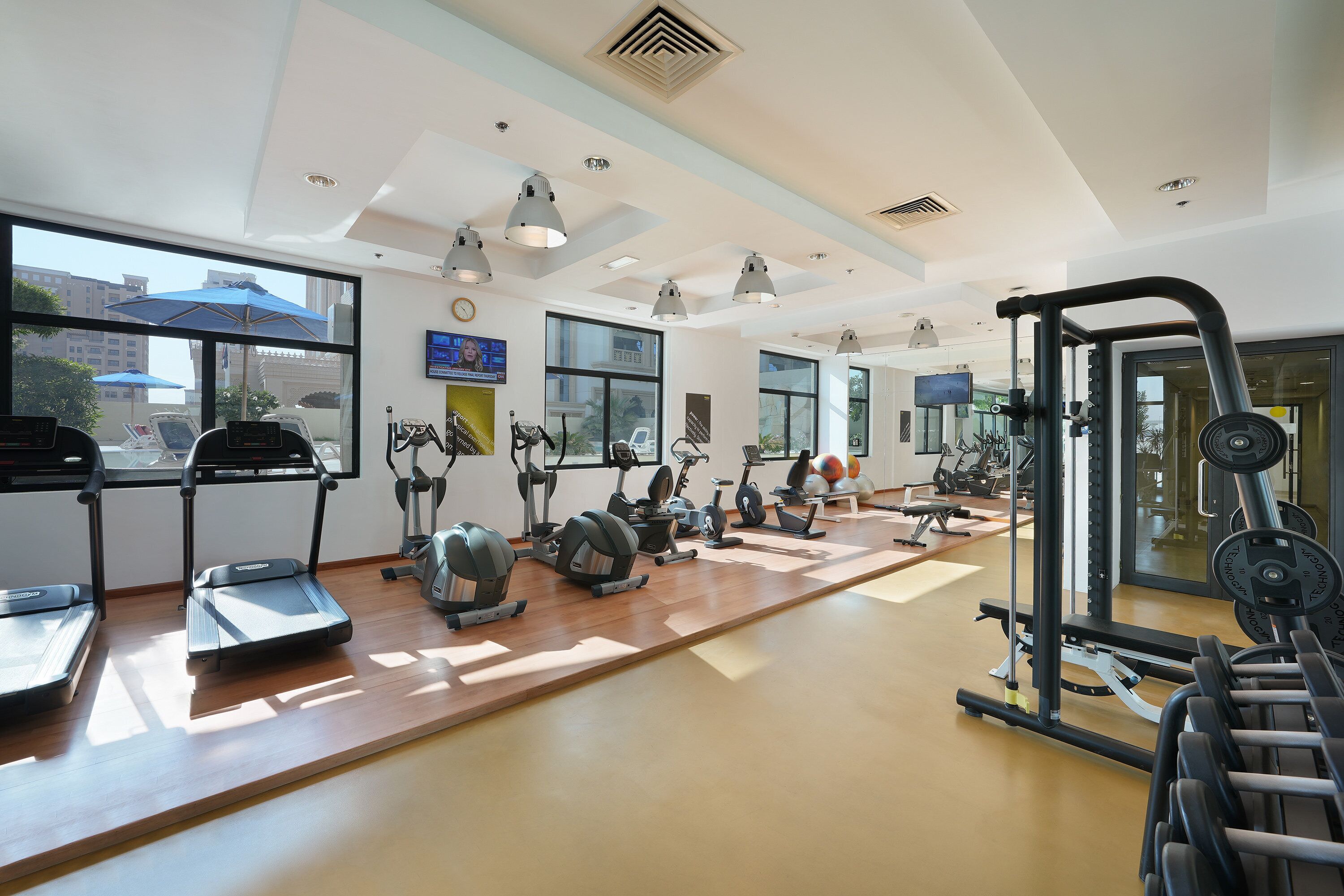 A spacious gym with treadmills, elliptical machines, and weight equipment.