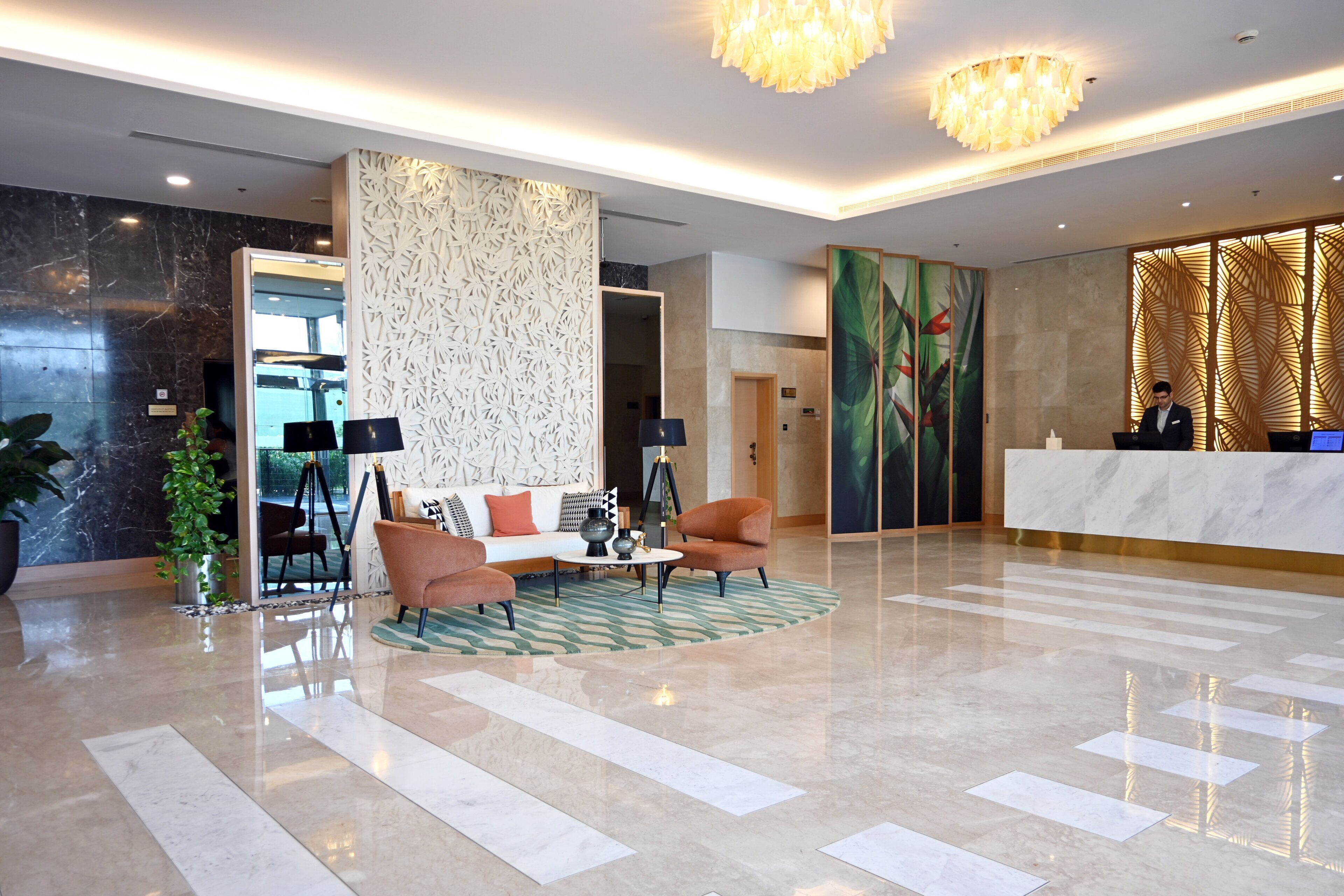 A modern lobby with a reception desk, seating area, and decorative elements.