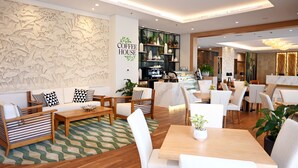 L'intérieur d'un café moderne, avec un espace salon, un bar et une salle à manger.