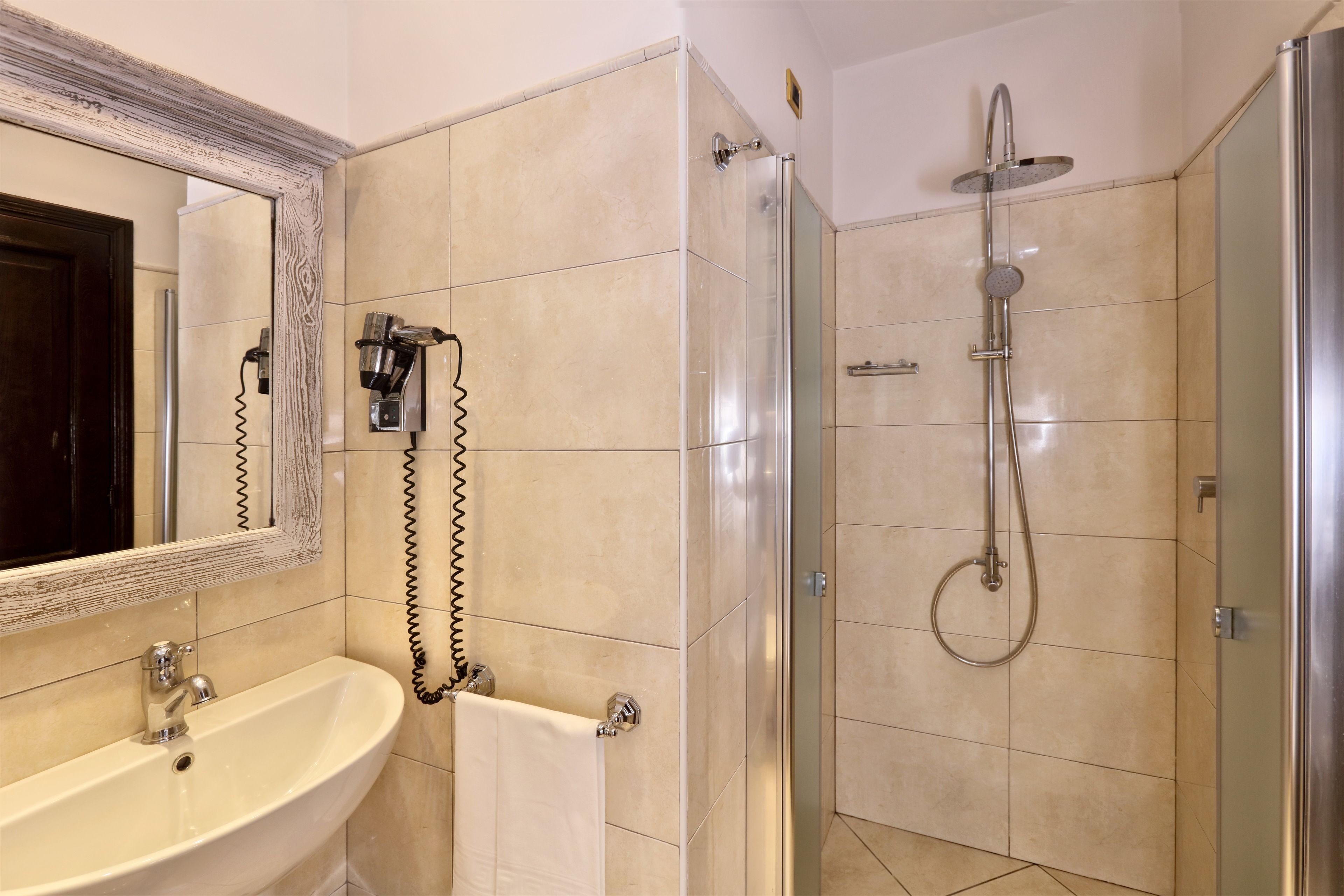 Ein Badezimmer mit Waschbecken, Spiegel und Dusche.