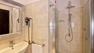 Ein Badezimmer mit Waschbecken, Spiegel und Dusche.