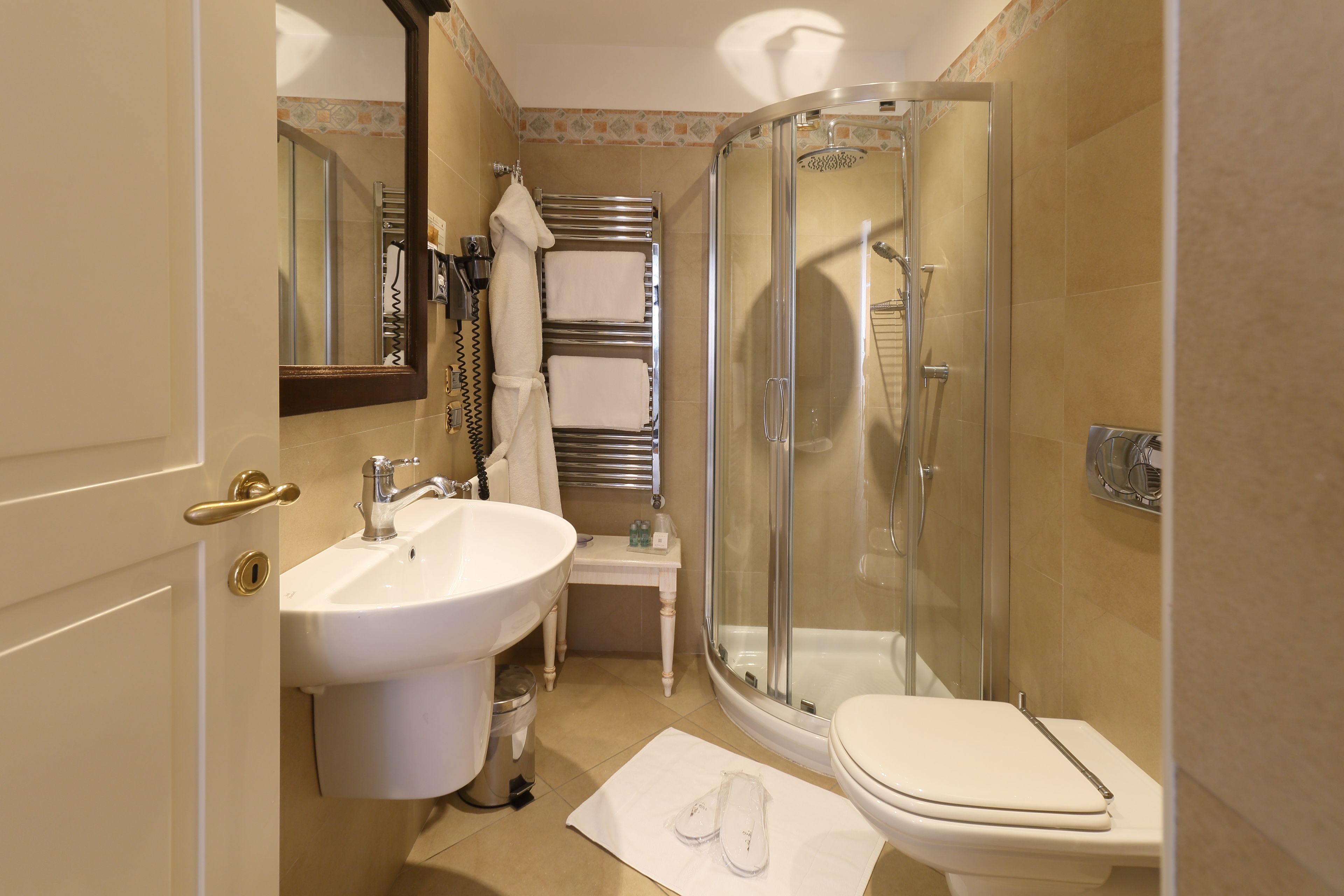 A bathroom with a glass-enclosed shower, a sink, and a toilet.