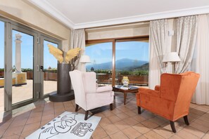 A room with two chairs, a table, and a view of mountains through large windows. - Villa Angela (Taormina)
