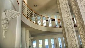Una escalera curva con barandilla blanca que conduce a un piso superior.