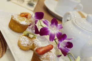 Un piatto da dessert con pasticcini e un teiera.