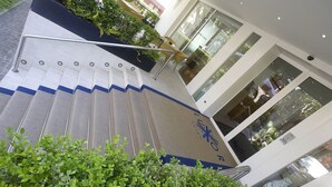 Una escalera con barandillas metálicas que lleva a la entrada de un edificio.