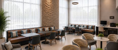 Un moderno vestíbulo de hotel con una pared de acento de piedra, zonas de estar y un centro de negocios.