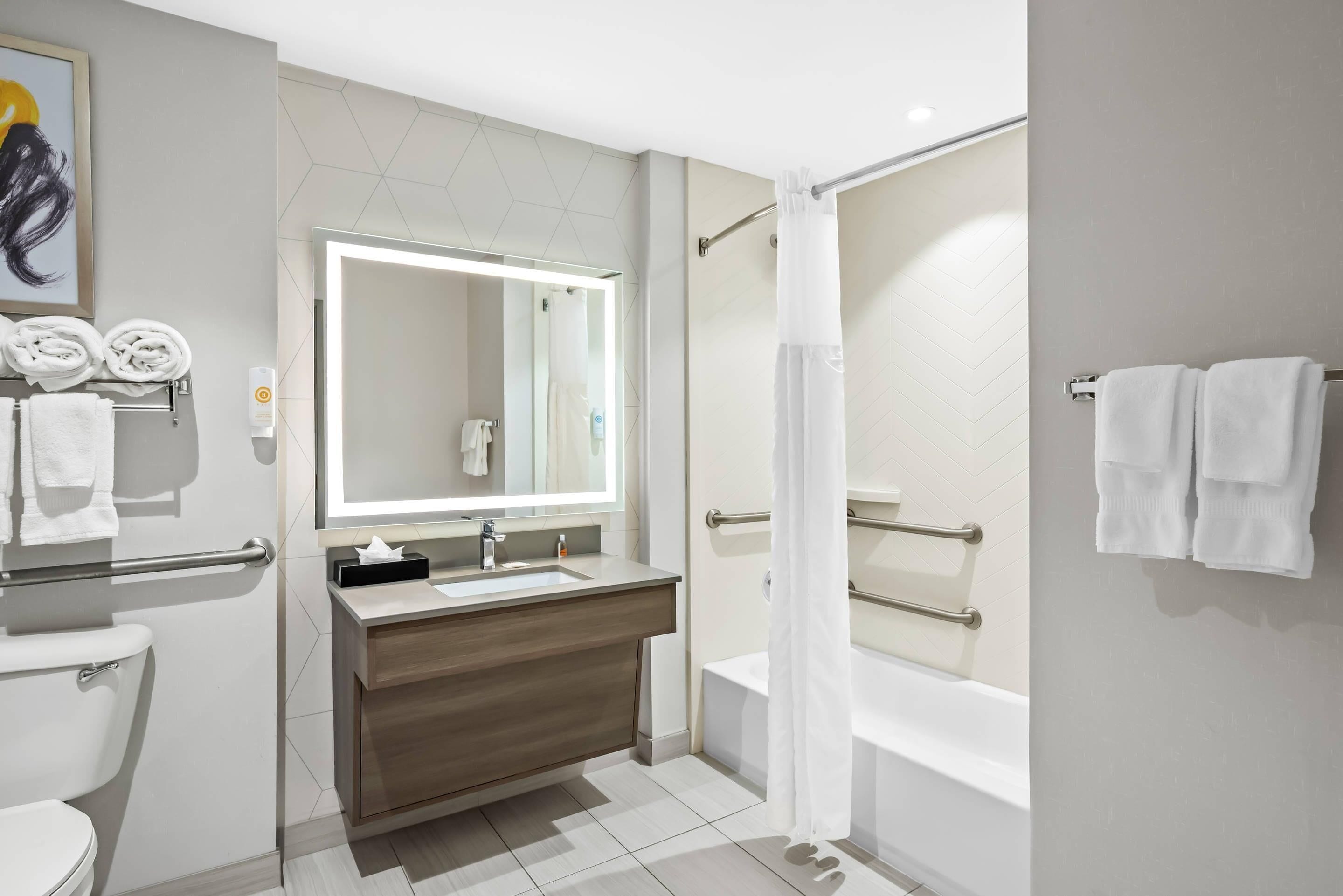 A modern bathroom with a toilet, sink, and bathtub.