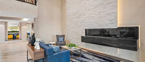 A spacious living area with a modern sofa, a coffee table, and a large wall-mounted TV.