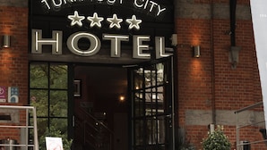 A hotel entrance with a sign reading "TURNOUT CITY HOTEL" and a staircase leading up to the door. - Turnhout City Hotel (Turnhout)