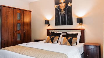 Una camera da letto con un letto grande, un armadio in legno e un quadro appeso al muro.