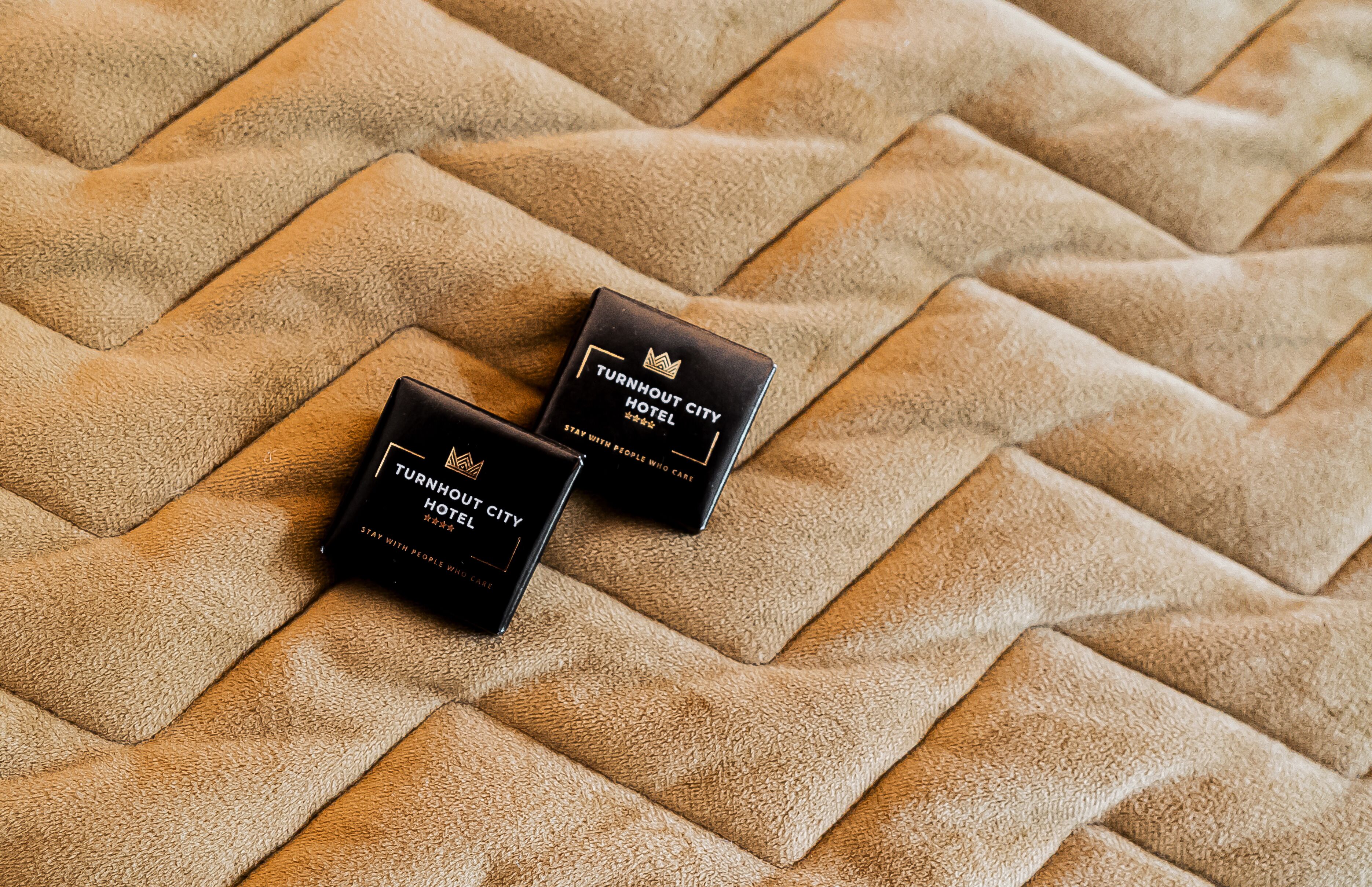 Two black business cards on a textured beige surface.