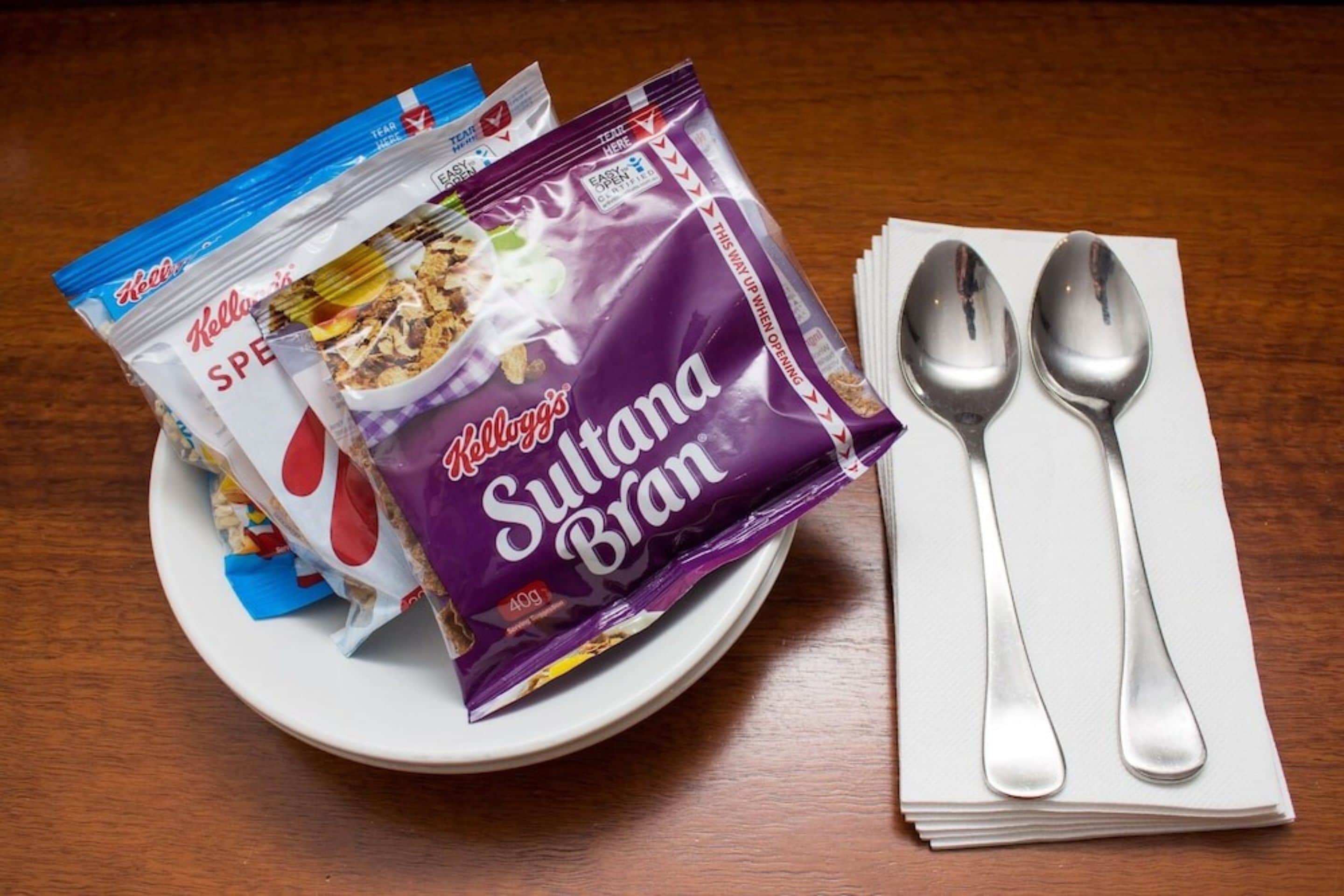 Un plato con un paquete de Kellogg's Sultana Bran y un paquete de Kellogg's Special K sobre una mesa de madera.