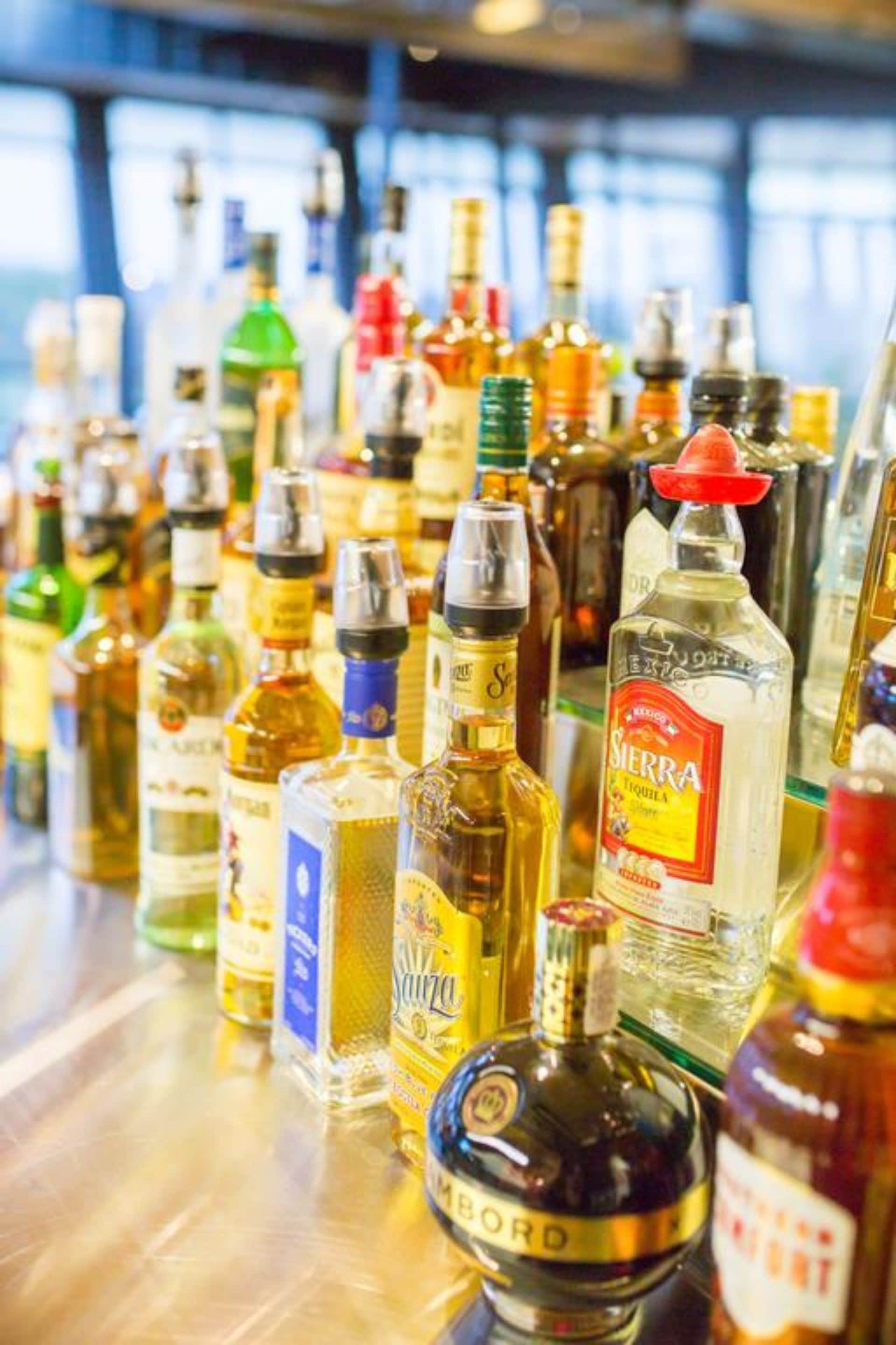 A variety of liquor bottles on a bar counter.