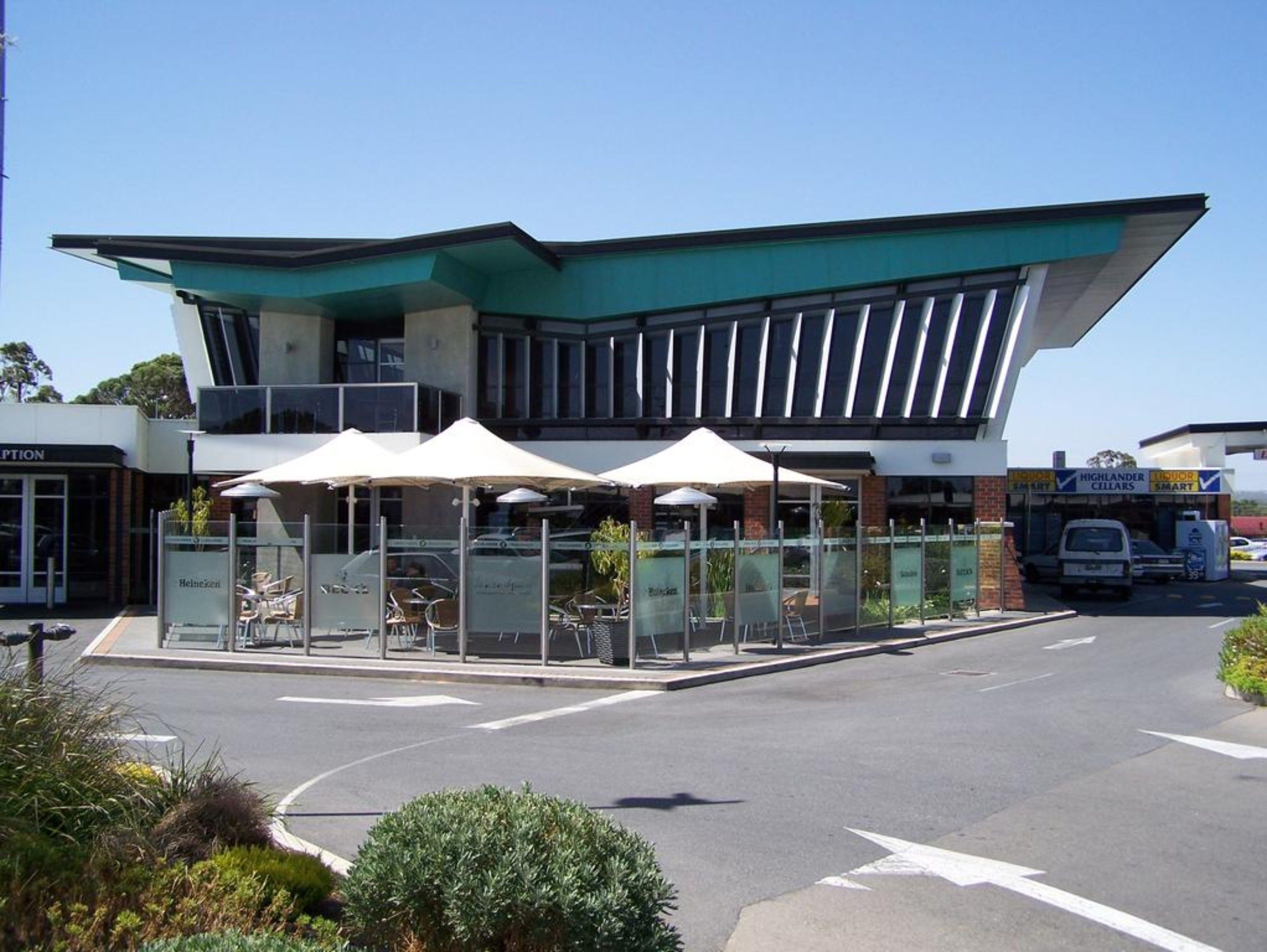 A modern building with a unique architectural design, featuring a large overhang and glass windows.