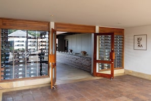 A hotel lobby with a wine rack, a wooden-framed door, and a wall-mounted sign. - Estelar Paipa Hotel Spa & Centro de Convenciones (Paipa)