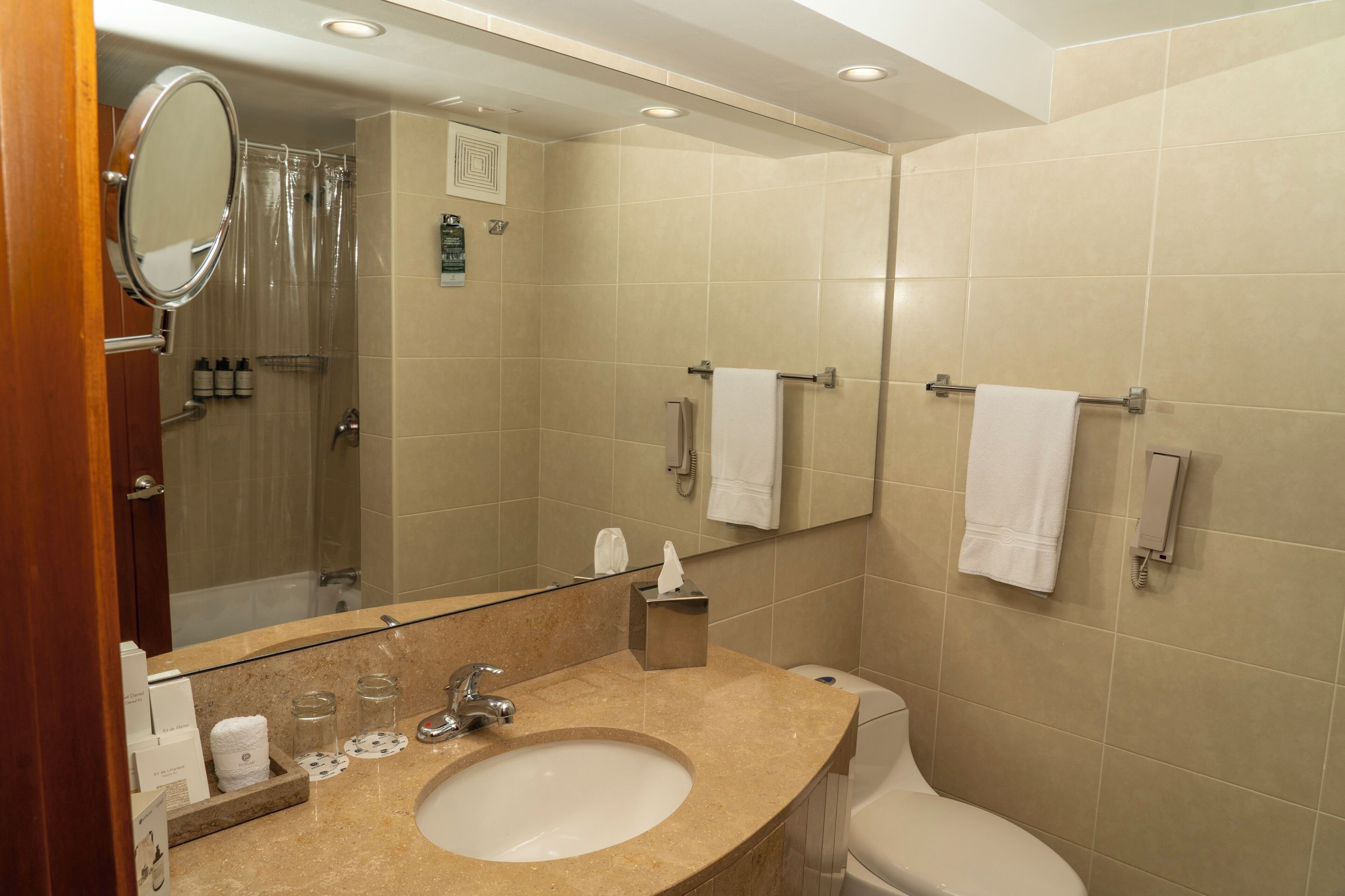 A bathroom with a sink, mirror, toilet, and shower.