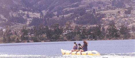 A yellow inflatable raft with two people on it, moving across a body of water.
