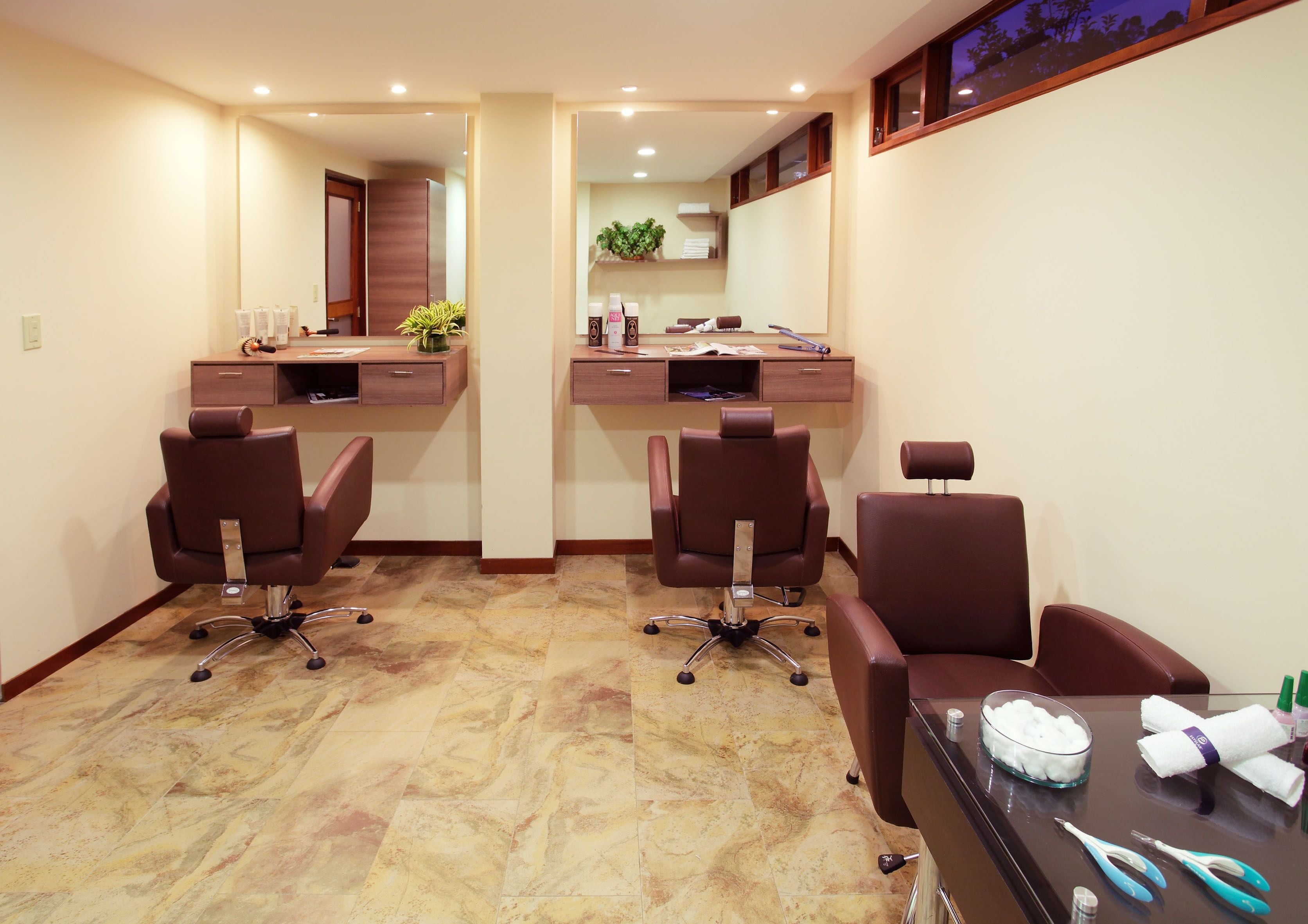 A hair salon with two workstations, each with a chair, a mirror, and a counter.