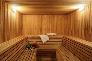 A wooden sauna with benches, a towel, and a teapot. - Estelar Paipa Hotel Spa & Centro de Convenciones (Paipa)