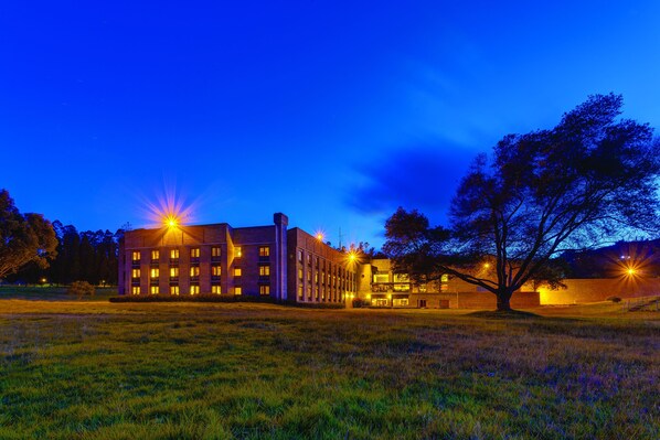 A building with multiple floors and a large tree in front. - Estelar Paipa Hotel Spa & Centro de Convenciones (Paipa)