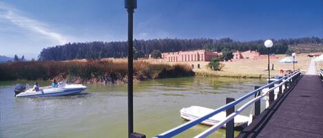 A wooden pier extending into a body of water with boats docked at the end.