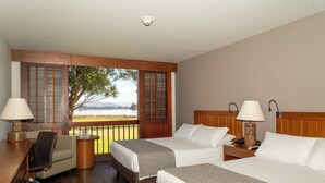 A hotel room with two beds, a desk, a chair, and a view of the outdoors. - Estelar Paipa Hotel Spa & Centro de Convenciones (Paipa)