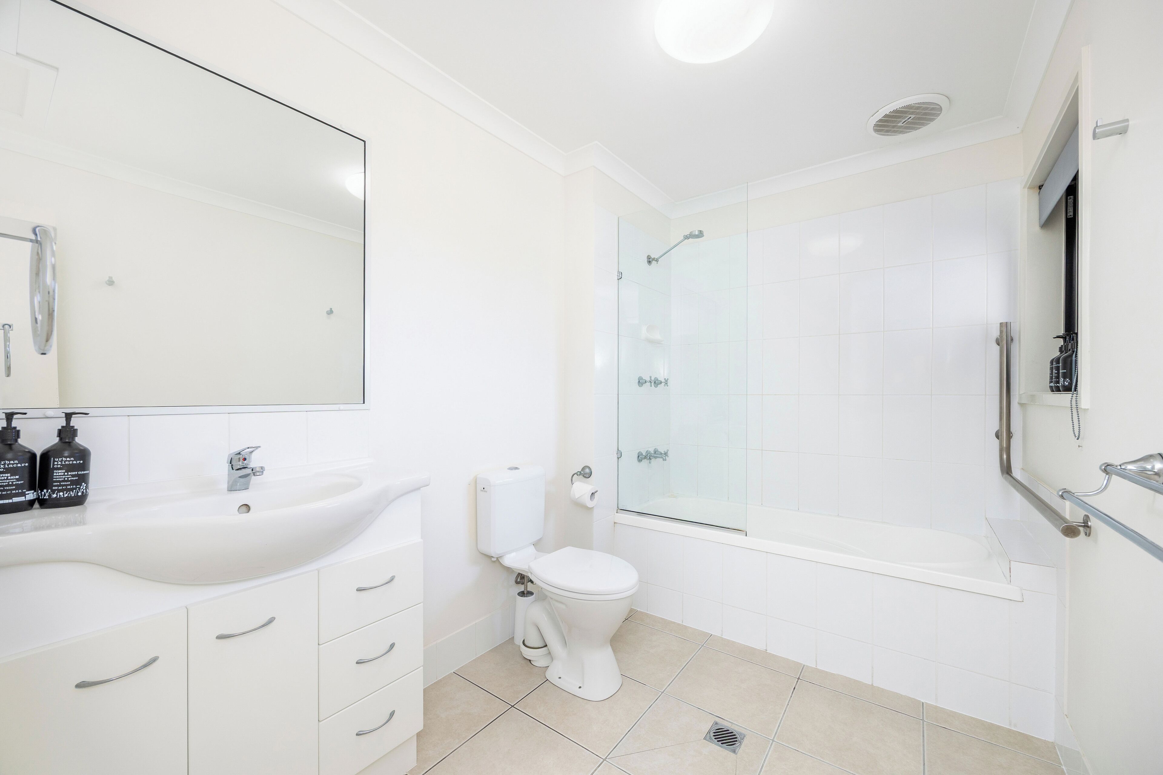 Un baño moderno con lavamanos grande, inodoro y ducha con cerramiento de vidrio.