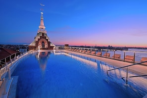 En säsongsöppen utomhuspool, parasoller och solstolar