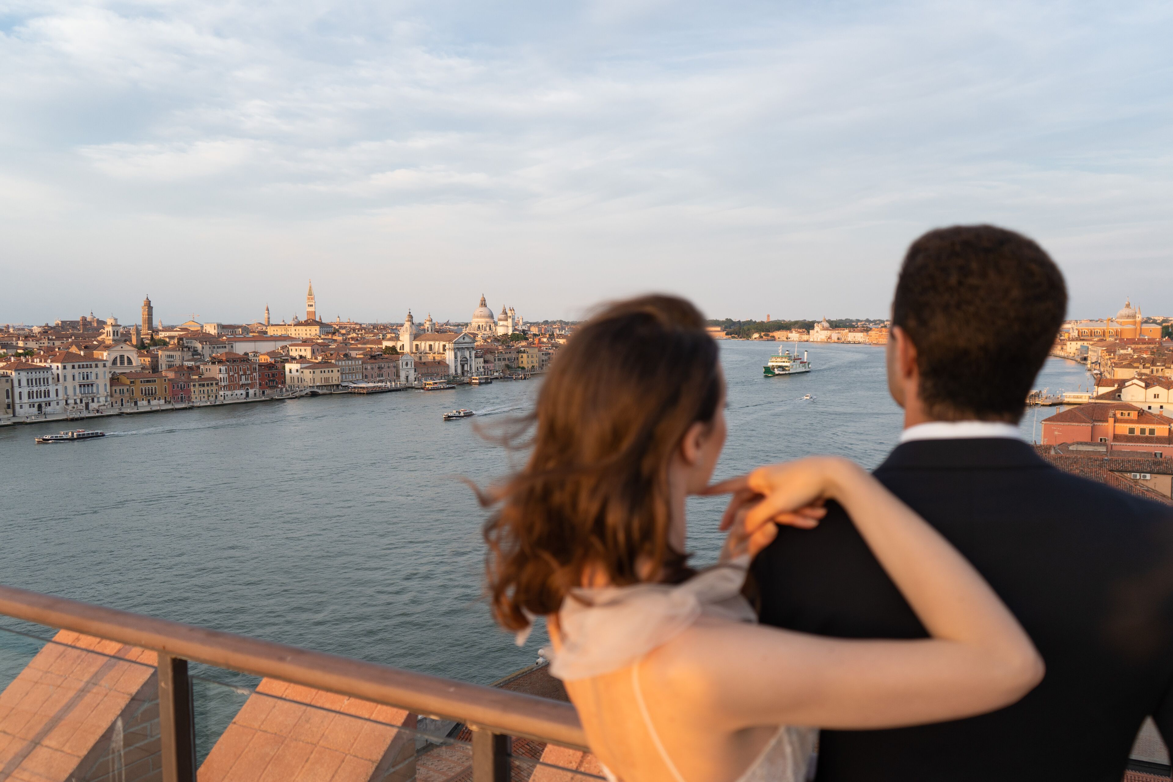 Una pareja contempla un paisaje urbano con un río y edificios históricos.
