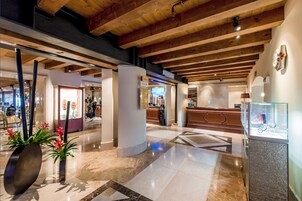 Un'ampia hall con soffitti alti, pavimenti in marmo lucido e arredi moderni.