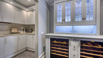 A kitchen with white cabinets, a granite countertop, and a wine rack.
