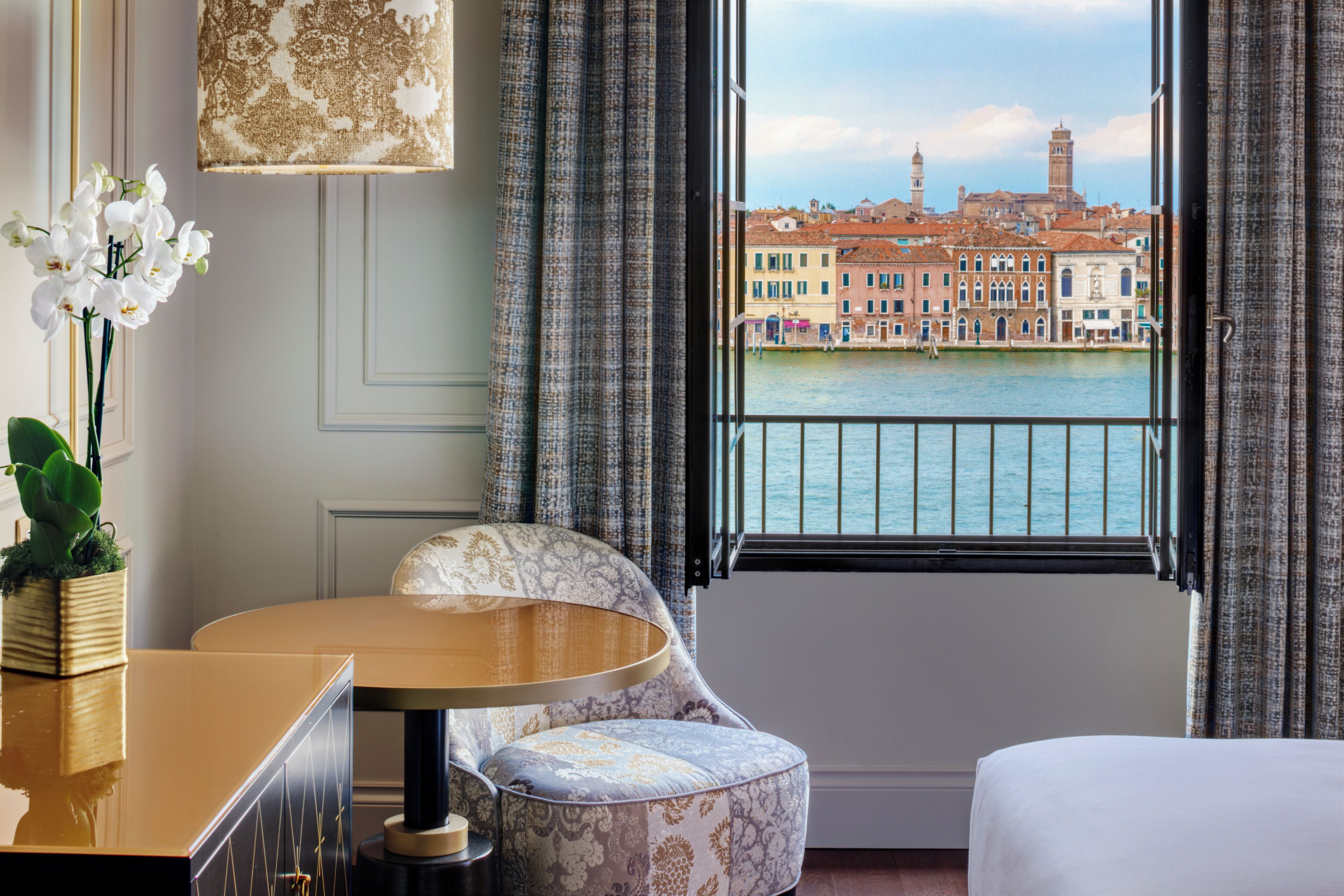 Habitación de hotel con vista a un canal y edificios históricos.