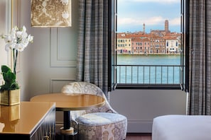 A hotel room with a view of a canal and historic buildings.