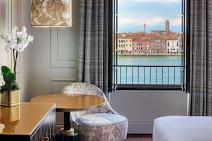 Una camera d'albergo con vista su un canale e palazzi storici.