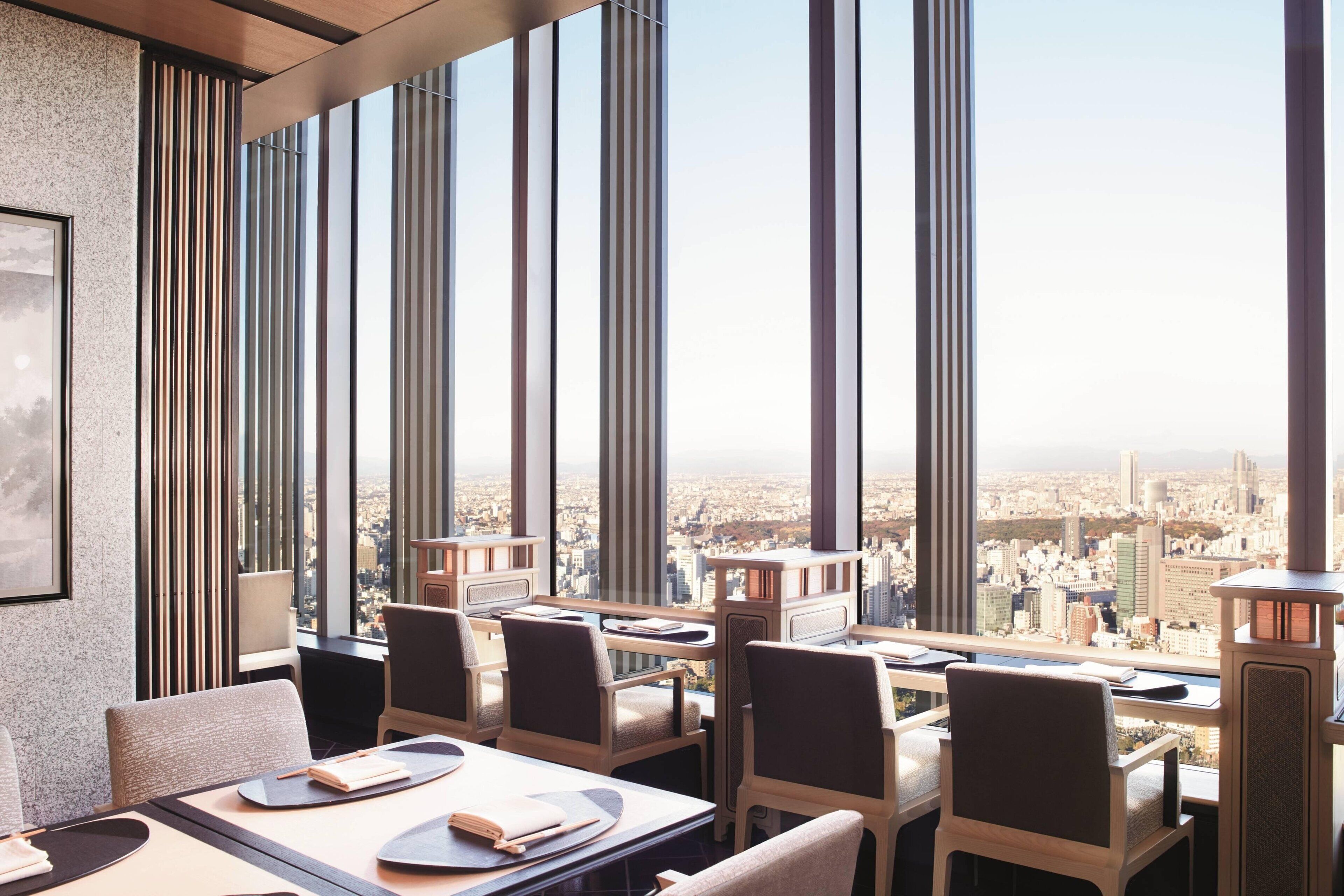 A high-rise restaurant with large windows offering a city view.