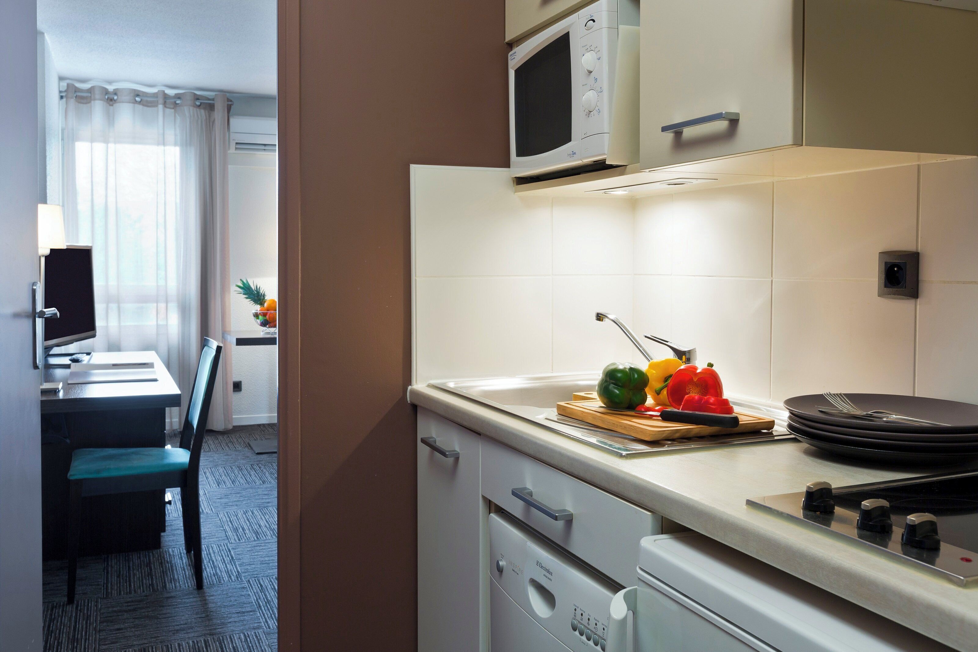 A modern kitchen with a microwave, stove, and a dining area with a table and chairs.