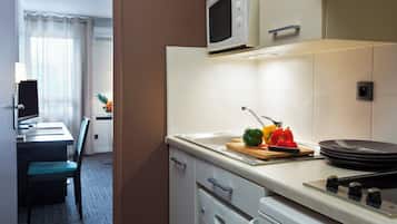 A modern kitchen with a microwave, stove, and a dining area with a table and chairs.