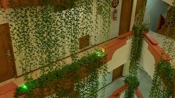 A multi-level atrium with hanging plants and a spiral staircase.