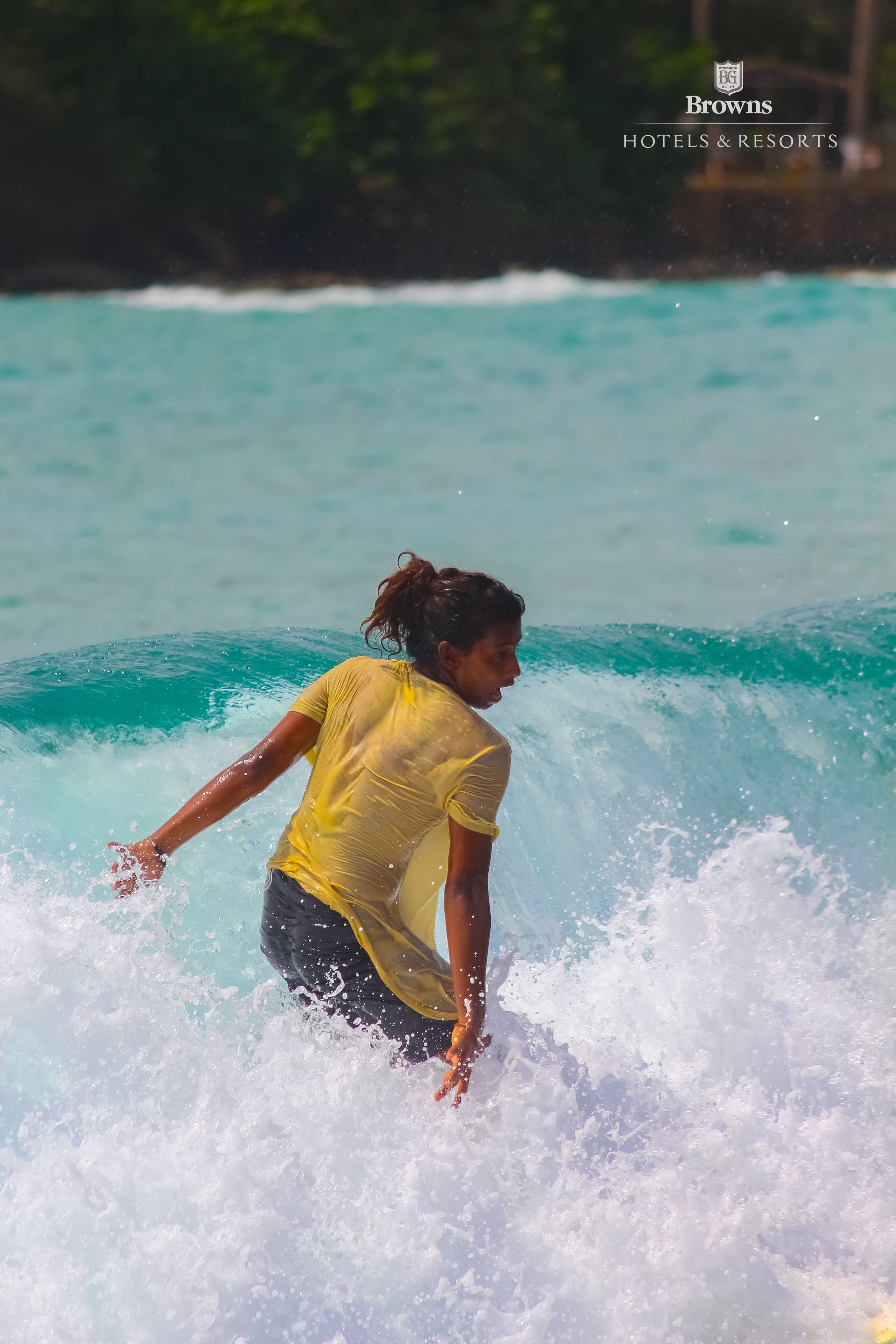 A person surfing in turquoise water.