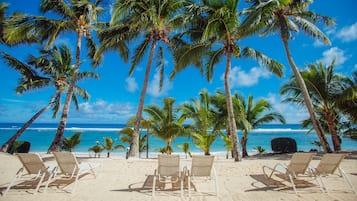 On the beach, white sand, sun-loungers, beach towels