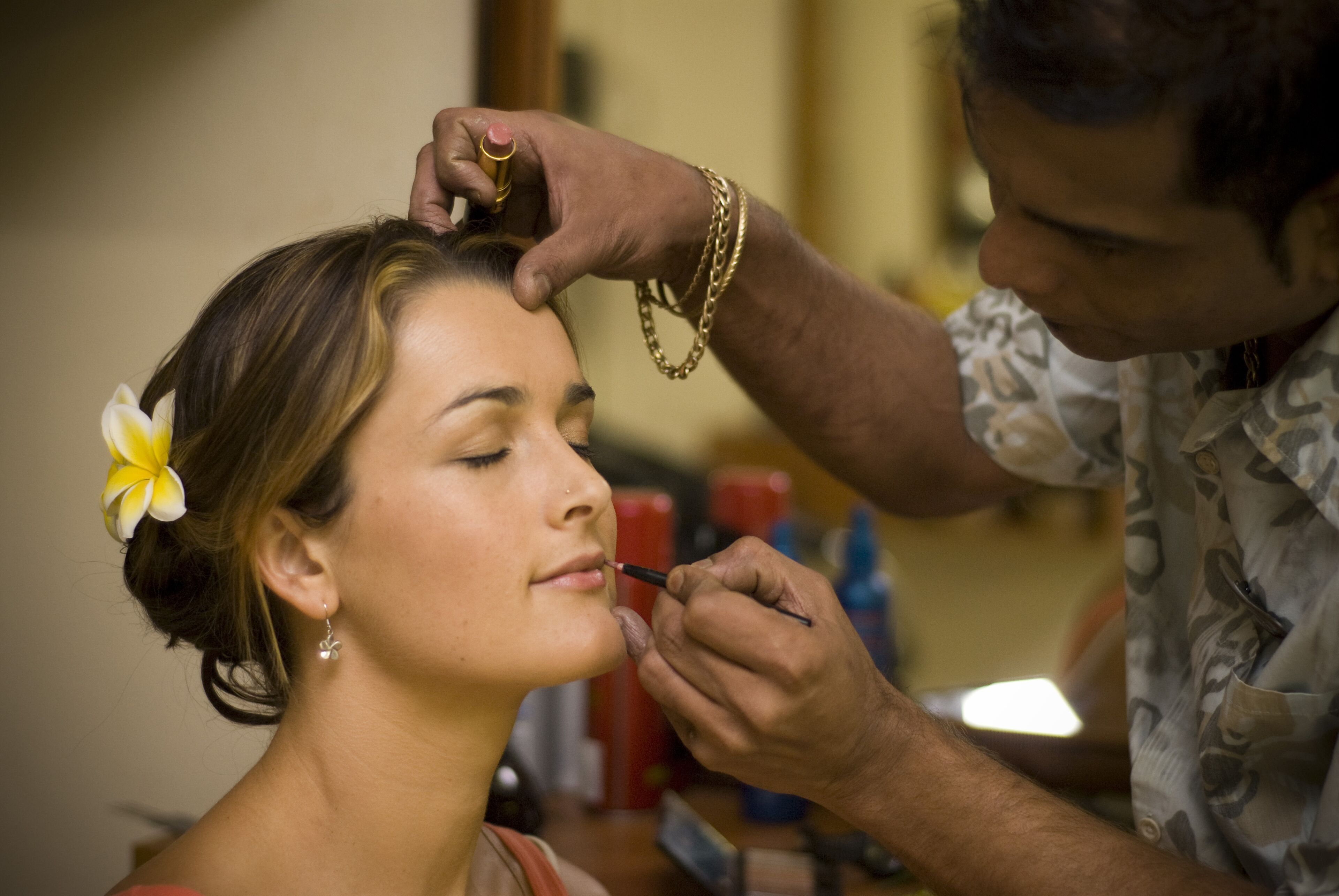 A person applying makeup to another individual.