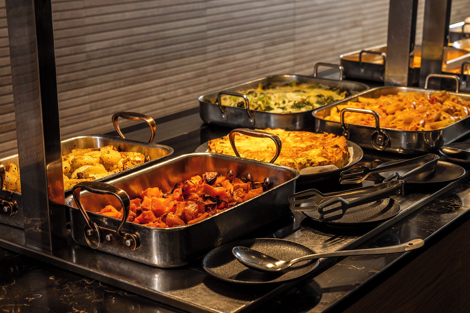 Ein Buffet mit verschiedenen Speisen in Metalltabletts.