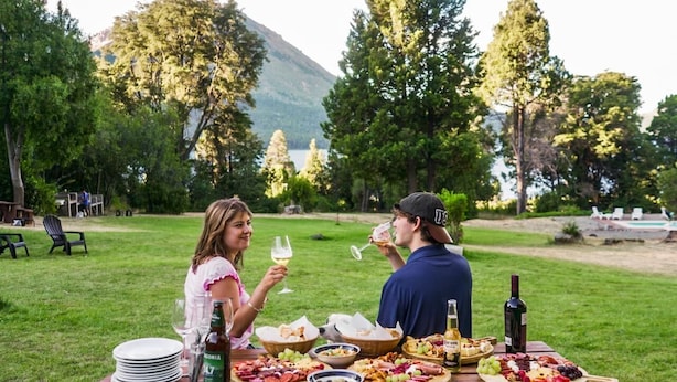 A picnic table set up outdoors with food and drinks.
