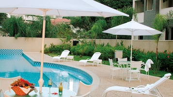 Alberca al aire libre y camastros